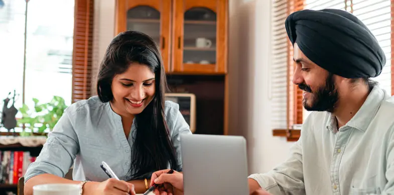 A man and woman smile as they look at a localised website.